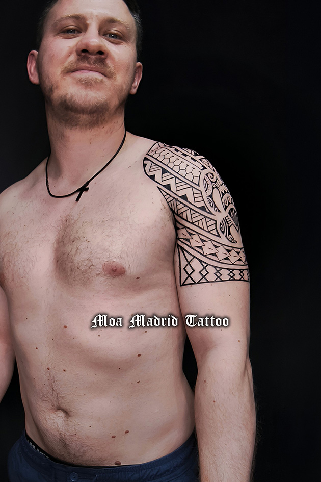 Vista delantera del tatuaje polinesio en hombro y parte superior del brazo