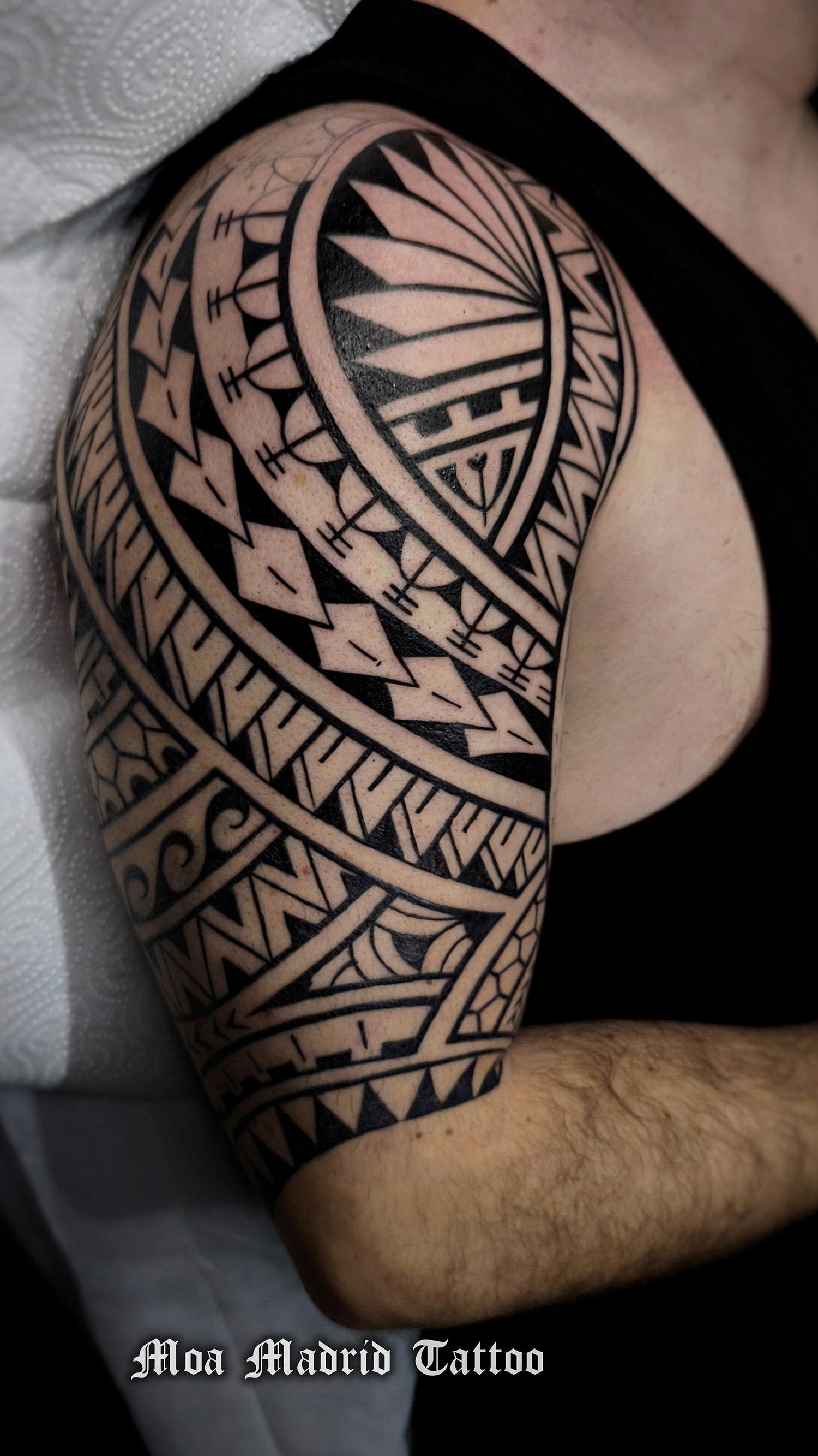 Tatuaje samoano en el brazo con dientes de tiburón y olas